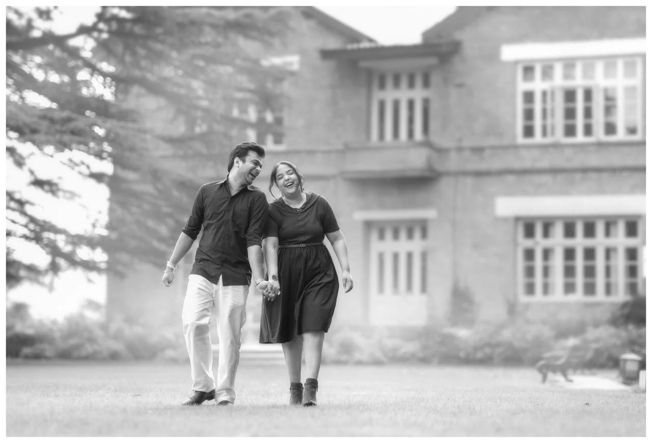 Daksha and Anand walking hand in hand outside a stately house