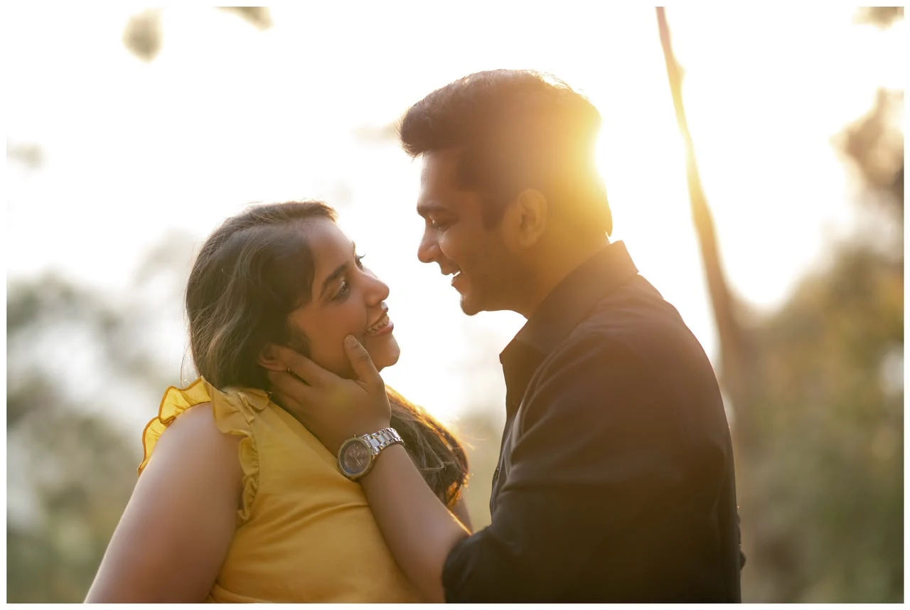 Daksha and Anand smiling at one another in the golden sunlight